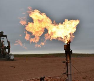 A flare burns natural gas at an oil well on Aug. 26, 2021, in Watford City, N.D. 